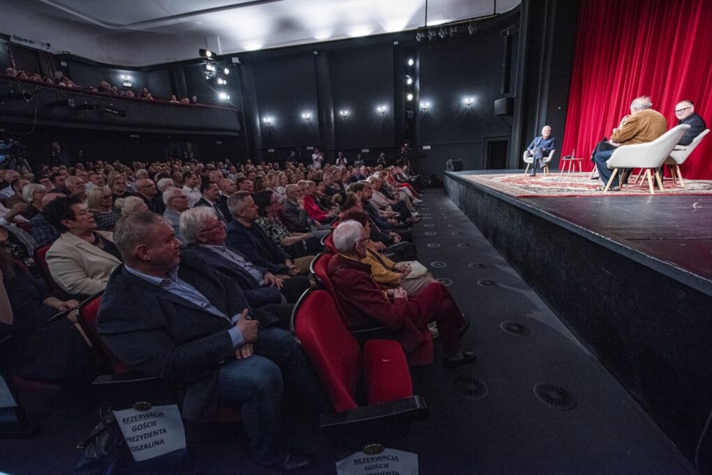 Widok na wypełnioną po brzegi widownię i scenę teatru podczas debaty z udziałem publiczności (kliknięcie powiększy zdjęcie).