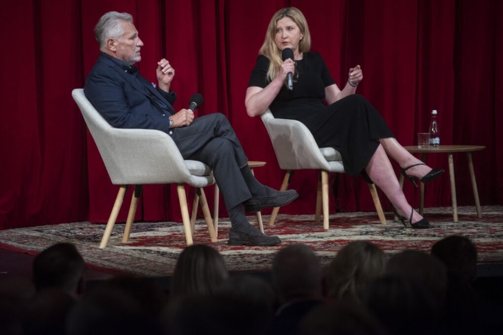 Kobieta i mężczyzna prowadzą rozmowę na scenie podczas debaty (kliknięcie powiększy zdjęcie).