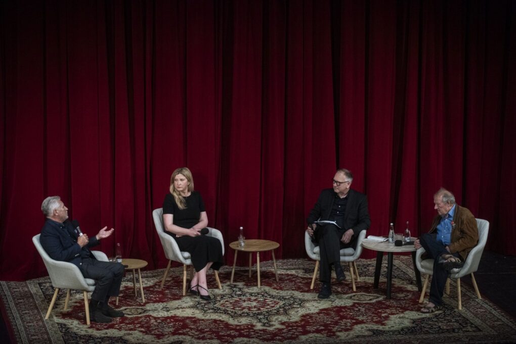 Cztery osoby siedzą na fotelach ustawionych na scenie i dyskutują (kliknięcie powiększy zdjęcie).