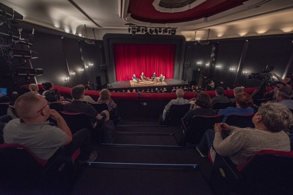 Szeroki widok sali teatralnej z balkonu z widownią i sceną podczas debaty (kliknięcie powiększy zdjęcie).