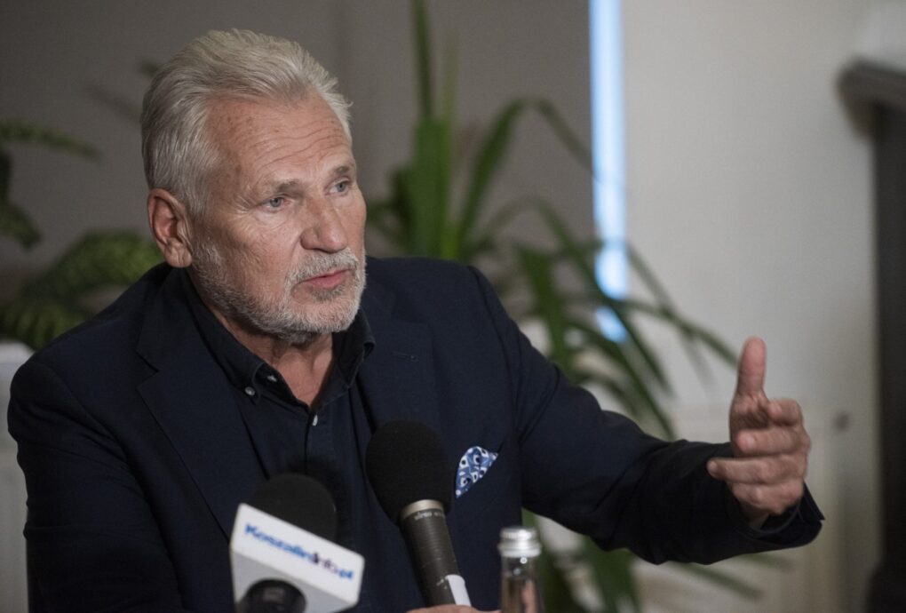 Aleksander Kwaśniewski przemawia do mikrofonu podczas debaty, gestykulując ręką (kliknięcie powiększy zdjęcie).