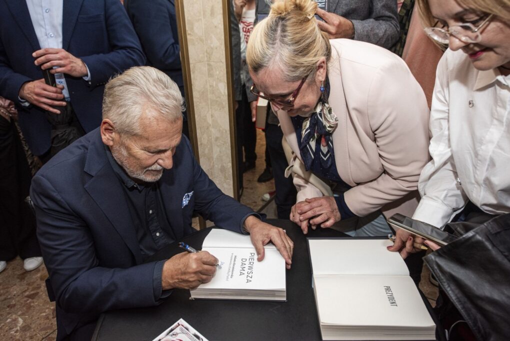 Aleksander Kwaśniewski podpisuje książkę dla uczestniczki spotkania (kliknięcie powiększy zdjęcie).