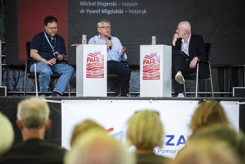 Panel dyskusyjny na scenie z udziałem trzech prelegentów podczas wydarzenia „Fale Historii” (kliknięcie powiększy zdjęcie).