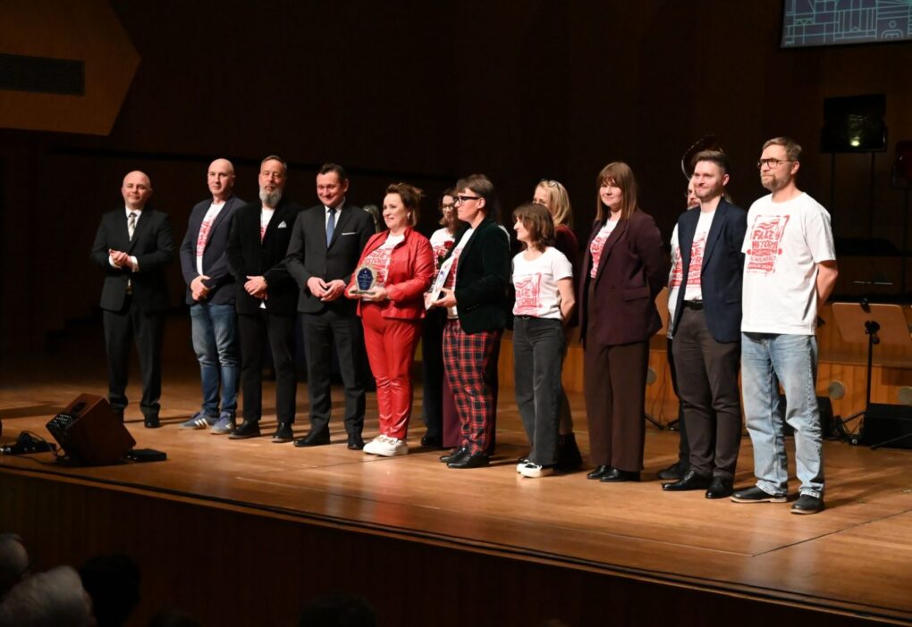 Pracownicy Muzeum, wspólnie z prezydentem i wiceprezydentem Koszalina stoją  w rzędzie na scenie podczas gali Koszalińskiej Kultury, część osób trzyma statuetki (kliknięcie powiększy zdjęcie).